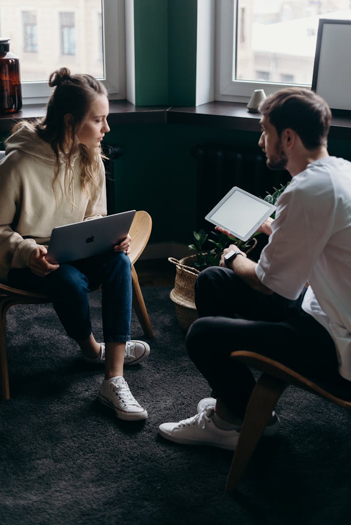 The Art of Drawing Readers In: Your attractive post title goes here Two adults having a tech-focused discussion in a cozy home setting.